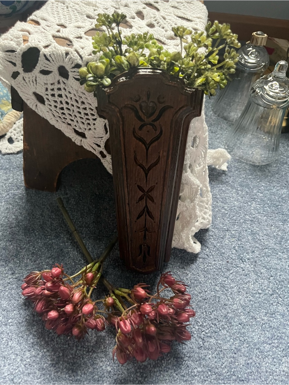 Carved Dark Wood Wall Pocket Vase will include a sprig of greenery